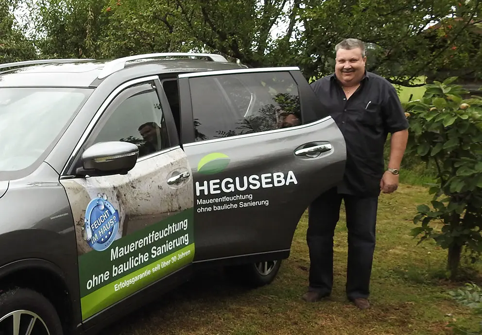 Inhaber Baltus Herzog neben dem Heguseba Firmenwagen, bereit Ihre Mauern zu trocknen.